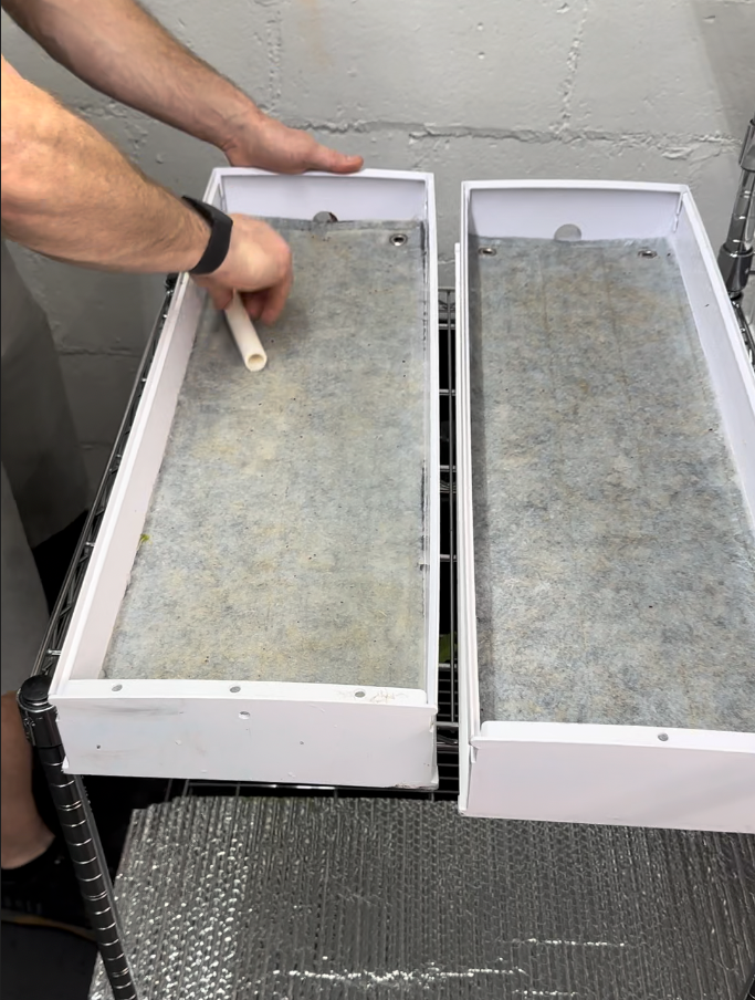 Rolling PVC pipe across grow mat